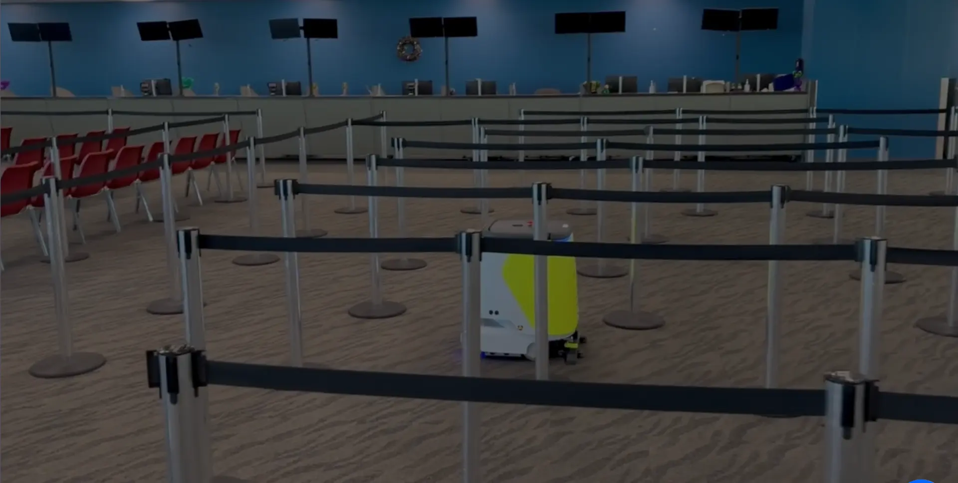 A commercial cleaning robot boxed in by a maze of queue stanchions and retractable belts in a service terminal